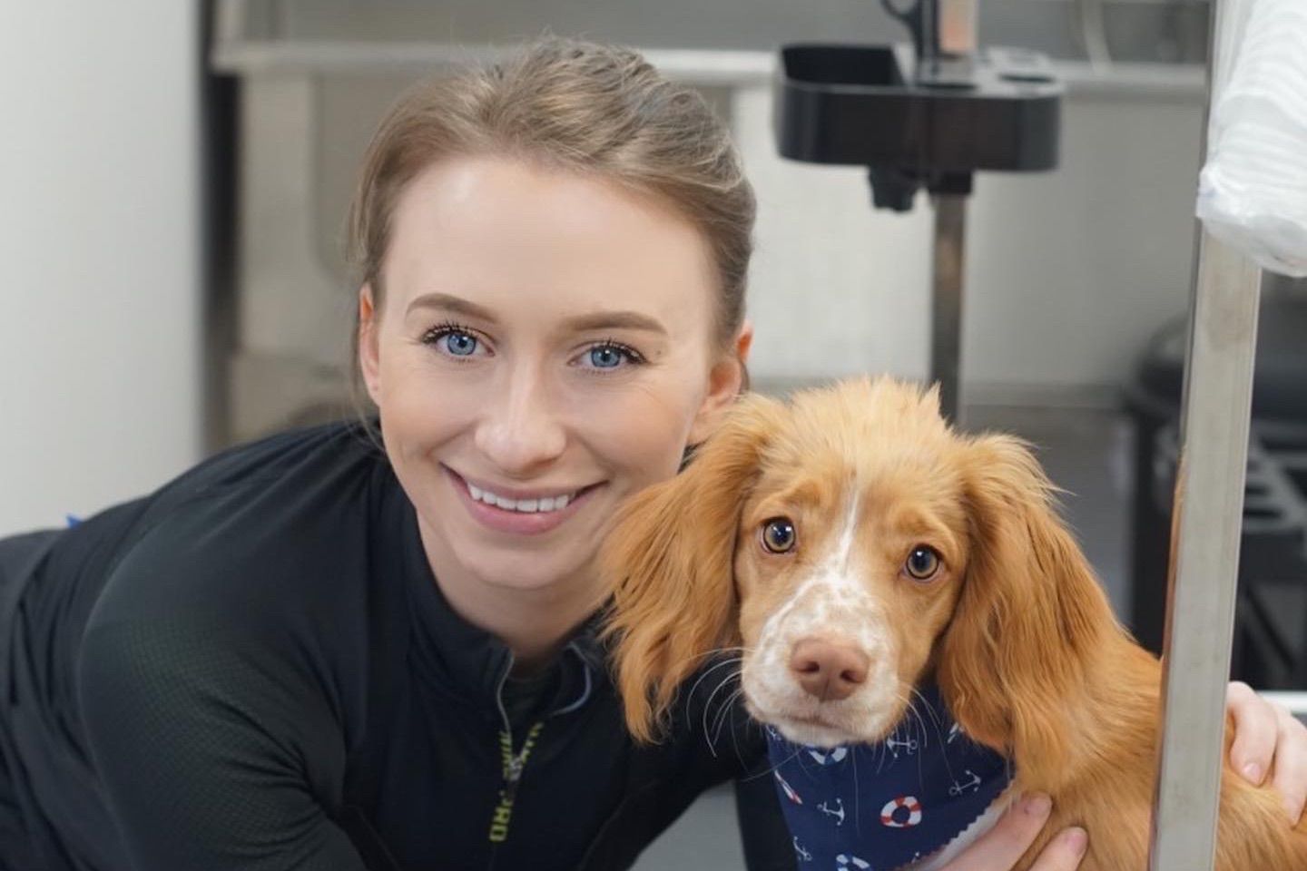 A groomer with a dog inside The Dog House salon